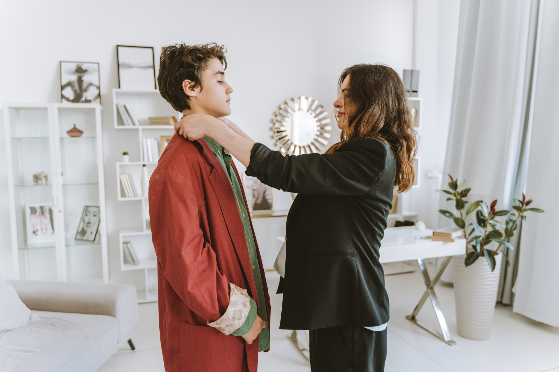 A Mother Fixing Her Son Coats