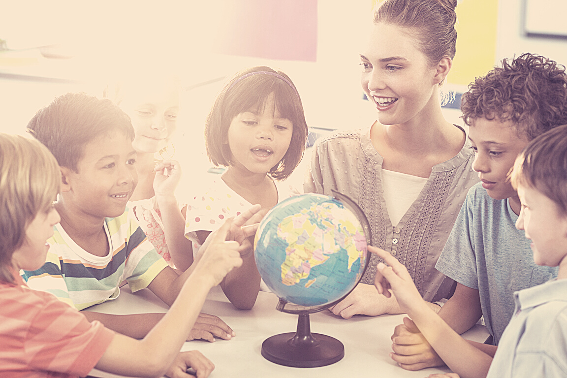 Female teacher showing globe to children